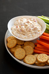Homemade Southern Pimento Cheese Dip with carrots, celery and crackers, side view. Close-up.