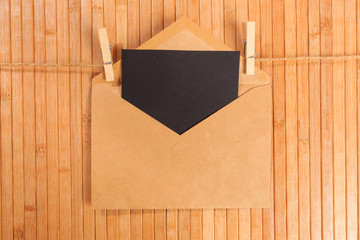 Old paper envelope hanging on rope on wooden background - Image