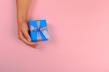 gift in female hands on a colored background top view. - Image