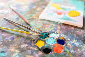 Obraz premium Closeup,artistic tools on colourful table,drawing and palette, paintbrush to painting watercolor on canvas,learning,activity and development of children,creative ideas,education, art concept