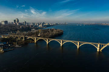 Aerial panoramic view on old arch railway Merefo-Kherson bridge across the Dnieper river in Dnepropetrovsk. View of the right bank of Dnipro city.