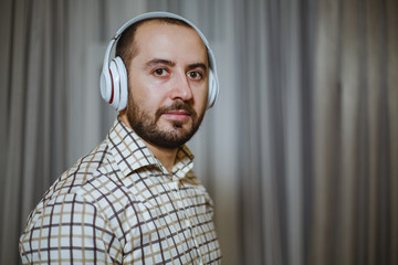 Handsome man listening to music in wireless headphones.Background texture.