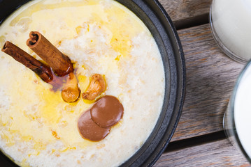 Traditional breakfast. Milk oatmeal with chocolate and granola. on a wooden table.