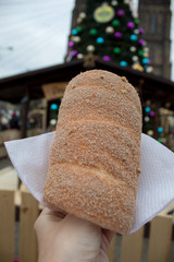 Trdelník is a kind of spit cake, made from rolled dough that is wrapped around a stick, then grilled and topped with sugar and walnut mix. National food in the Prague Christmas market.