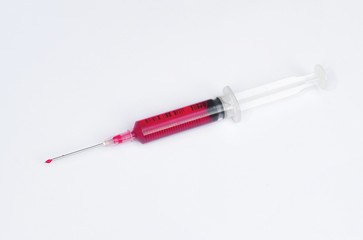 syringe with drop red blood liquid isolated on white background