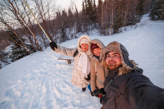 Happy family takes a selfie in the winter forest.