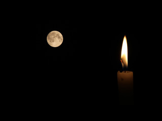 One light candle burning brightly in the black background