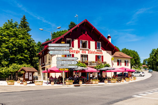 Auberge du Herisson at a crossing in the Jura region with street signs at a central traffic knot