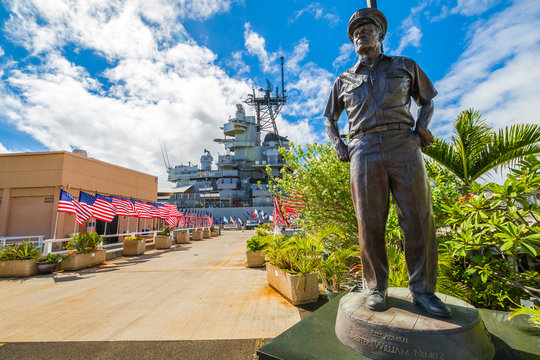 HONOLULU, OAHU, HAWAII, USA - AUGUST 21, 2016: bronze statue of Admiral Chester W. Nimitz at battleship USS Missouri in Pearl Harbor Memorial with American flags. Commander in chief of Pacific Fleet.