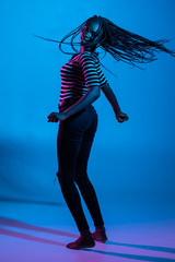 Portrait of lovely woman dance and play with hair isolated over violet background