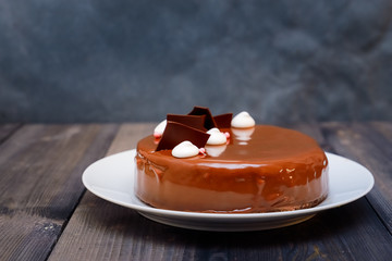 A large portion of a chocolate glossy cake with bright layers of chocolate souffle is presented.