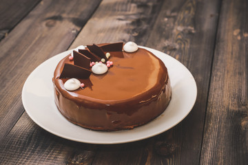 A large portion of a chocolate glossy cake with bright layers of chocolate souffle is presented.