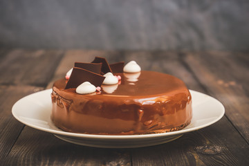 A large portion of a chocolate glossy cake with bright layers of chocolate souffle is presented.