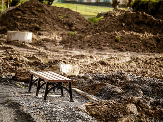Metal bench installed, park renovation. Ground work in progress. Selective focus.
