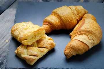 In the center of composition French croissant On graphite colors of flat stone meringue tiles there are shaped cookies