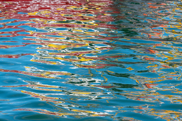 Colorful reflection of a boat in the water .