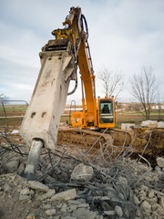Fototapeta premium Close-up of a hydraulic breaker of a yellow excavator working on