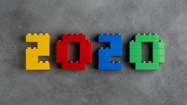 2020 numerals made of colorful plastic toy blocks on concrete textured background. top view. can be used as a new year greeting card.