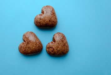 Valentine's flat lay with love chocolate gingerbread heart on colorful blue background, greeting card copy space top view. The celebration of Valentine's Day.