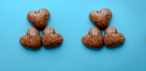 Valentine's flat lay with love chocolate gingerbread heart on colorful blue background, greeting card copy space top view. The celebration of Valentine's Day.