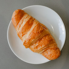 Fresh and tasty croissant on white plate