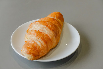 Fresh and tasty croissant on white plate
