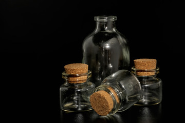 Small glass bottles with corks on a black background