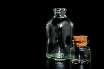 Small glass bottles with corks on a black background