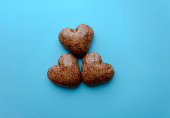 Valentine's flat lay with love chocolate gingerbread heart on colorful blue background, greeting card copy space top view. The celebration of Valentine's Day.