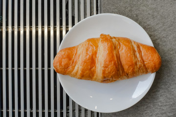 Fresh and tasty croissant on white plate