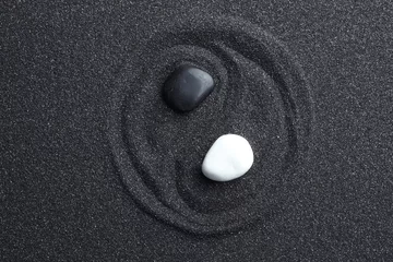 Foto auf Acrylglas Krankenhaus Yin-Yang-Symbol mit Steinen auf schwarzem Sand, Ansicht von oben. Zen-Konzept