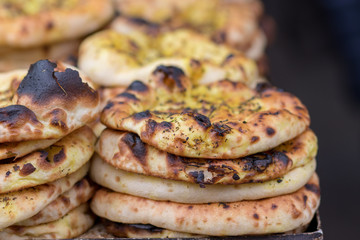 Authentic, flat bread with Za'atar, baked, stacked. The market in Jerusalem. Arab style. Blurred black background.