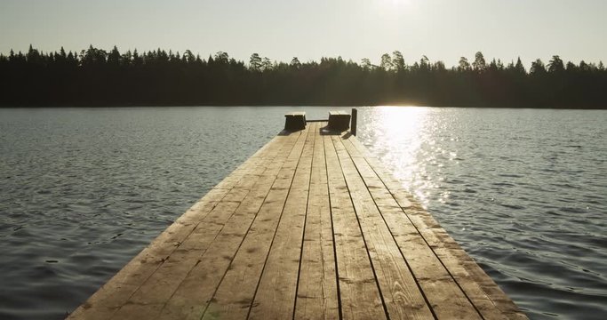 Wooden jetty on lake in sunny morning