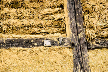 close up view of constructing a traditional half-timbered house with wooden beams and straw and clay