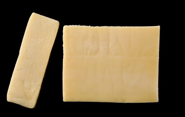 Cheese block slices isolated on black background, top view