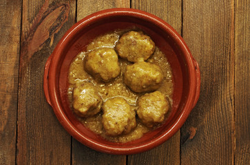 Meatballs in sauce, in casserole on wood