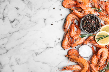 Delicious cooked shrimps with lemon and spices on white marble table, flat lay. Space for text