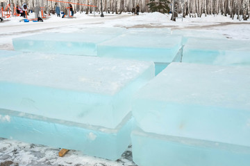 Ice cut into blocks. Ice bricks lie on wooden props. Build an ice town