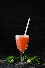Fresh grapefruit juice in a glass. Top view. On a black background.