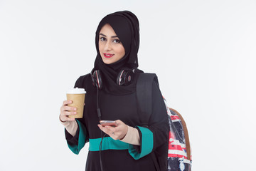 arab student wearing hijab holding mobile and coffee cup