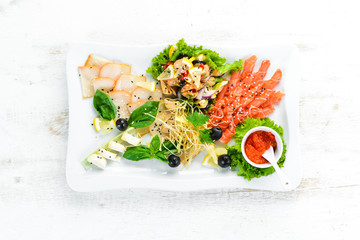 Assorted seafood on a plate. Salmon, caviar, mussels, octopuses. Restaurant dishes. Top view. Free space for your text.