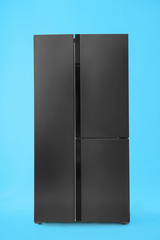 Modern stainless steel refrigerator on blue background