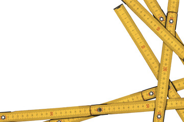 Close-up of old yellow folding wooden rulers isolated on white background with copy space