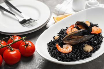 Delicious black risotto with seafood on marble table