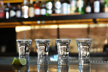 Mexican Tequila shots with lime slices on bar counter