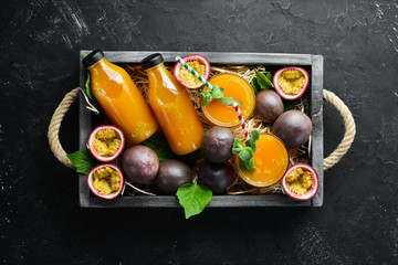 Passion fruits juice and fruit on a black background. Tropical Fruits. Top view. Free space for text.
