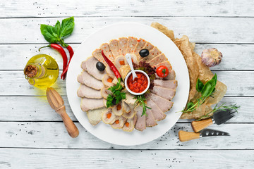 Slicing baked meat and sausage with sauce. Restaurant dishes. Top view. Free space for your text.