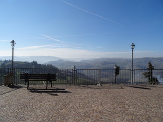 Lonely bench facing a natural landscape with hills