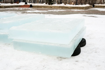 Ice blocks lie on rubber tires. Ice for building an ice town