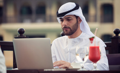 Arab young businessman working with laptop in cafe